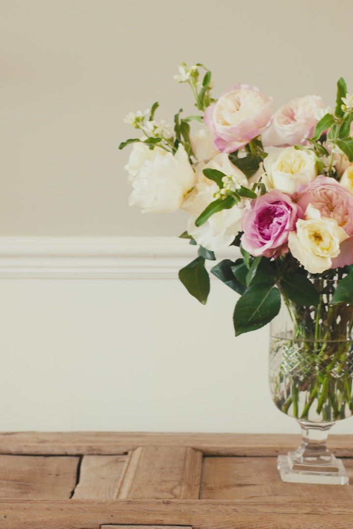 pink and cream vase or roses transitioning from bud to bloom